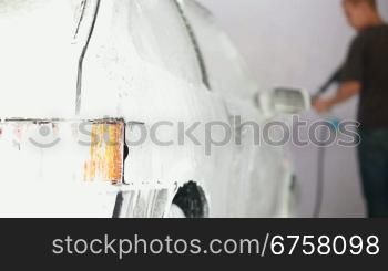 worker puts on a car wash foam