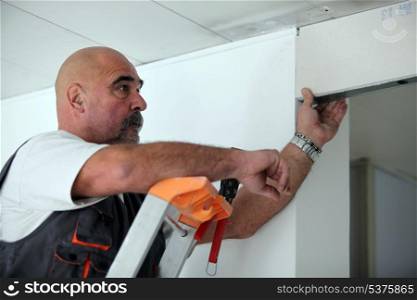 Worker putting a doorway in a partition wall