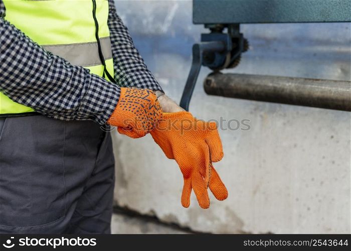 worker putting protective gloves