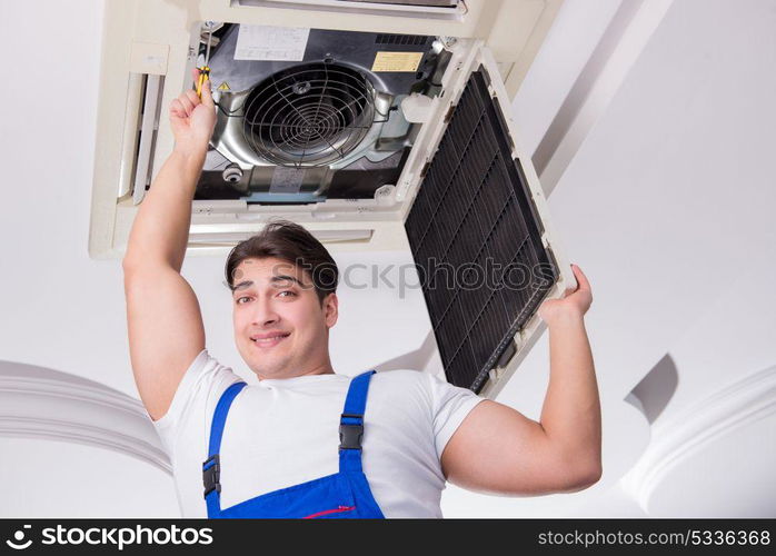 Worker repairing ceiling air conditioning unit