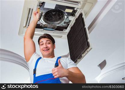 Worker repairing ceiling air conditioning unit
