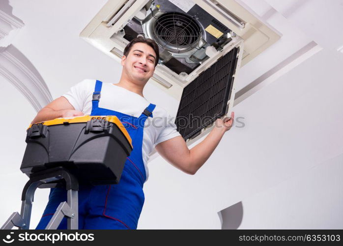 Worker repairing ceiling air conditioning unit