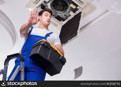 Worker repairing ceiling air conditioning unit