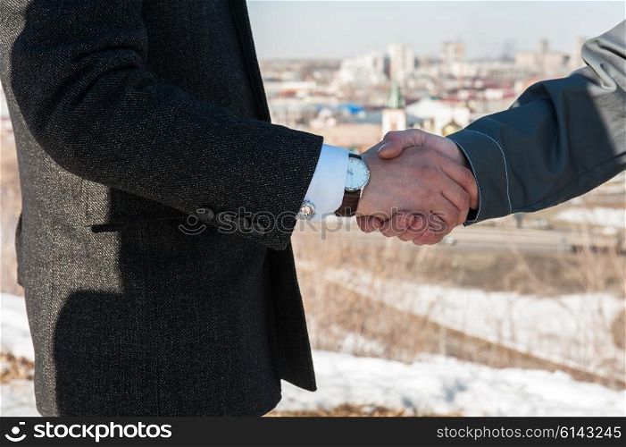 worker shakes hands with businessman. Industry worker with glove shakes hands with businessman