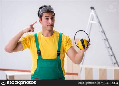 Worker showing the importnace of wearing noise cancelling headph. Worker showing the importnace of wearing noise cancelling headphones