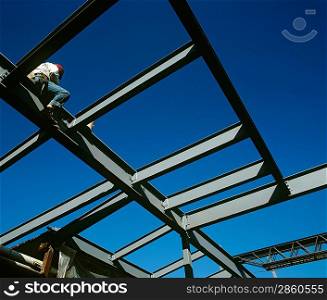 Worker sitting on iron construction low angle view