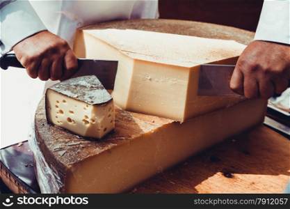 Worker slicing the cheese. Close up of Cutting cheese.