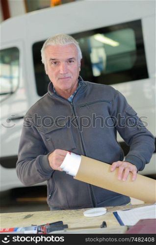 Worker taking paper from cardboard roll