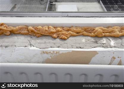 Worker using a polyurethane foam for installation of window sill. Installing window sill restoration,renovation house,building close-up. Worker using a polyurethane foam for installation of window sill. Installing window sill restoration,renovation house,building