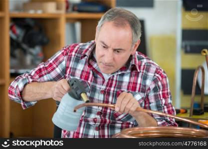 worker using blowtorch for soldering copper fittings