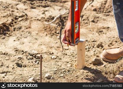 Worker Using Level At Construction Site