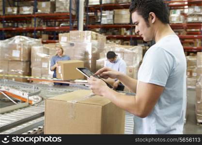 Worker Using Tablet Computer In Distribution Warehouse