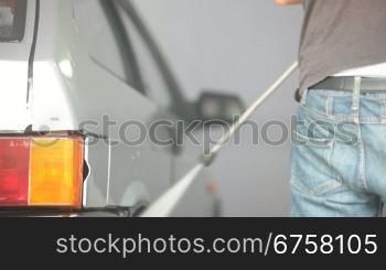 worker wash car with water pressure machine