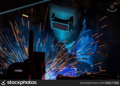 worker welding automotive part in car factory