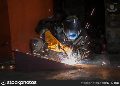 worker welding metal. worker welding metal with sparks at factory