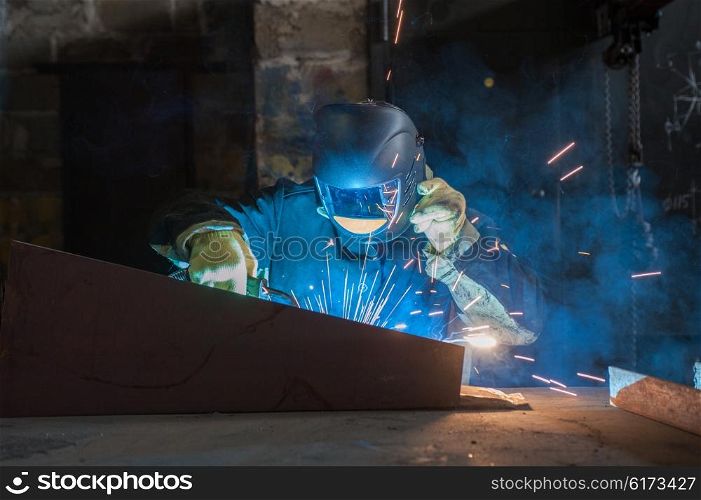 worker welding metal. worker welding metal with sparks at factory