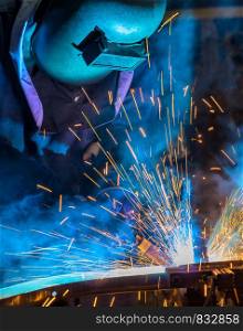 Worker welding steel in car factory