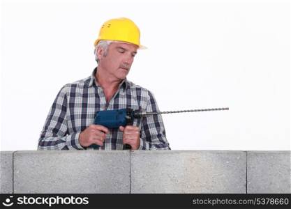 Worker with a masonry drill