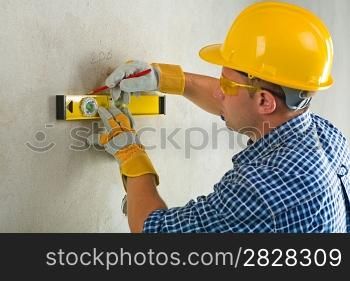 worker with construction level and pencil
