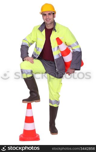 Worker with foot on top of cone signaling