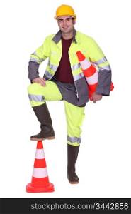Worker with foot on top of cone signaling