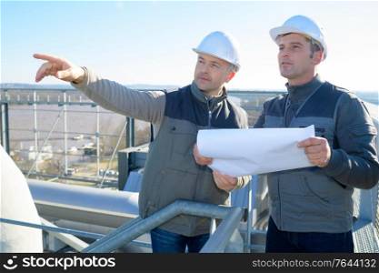 worker with manager inspecting industrial area