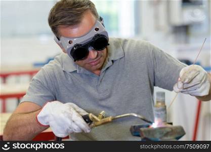 worker with protective goggles looking down