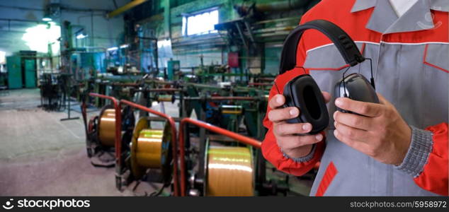 Worker with protective headphone. Worker with protective headphone at man hands at industrial factory