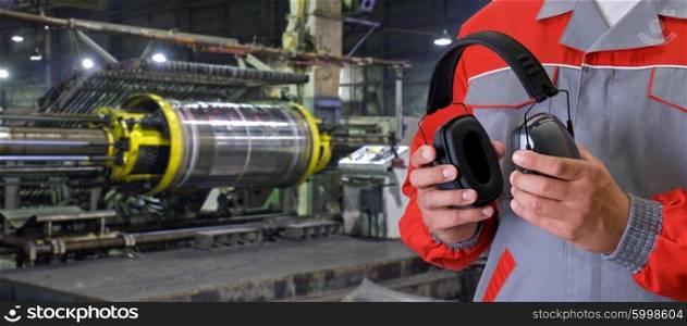 Worker with protective headphone. Worker with protective headphone at man hands at industrial factory