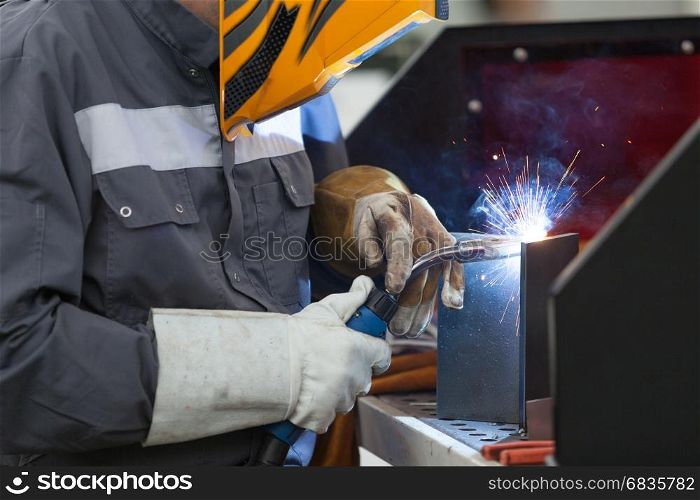 Worker with protective mask welding metal