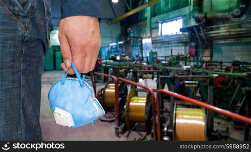 Worker with protective respirator . Worker with protective respirator at man hands at industrial factory