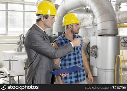 Worker with supervisor inspecting industrial area