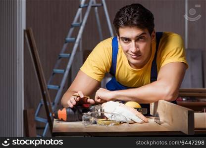 Worker working in repair workshop in woodworking concept