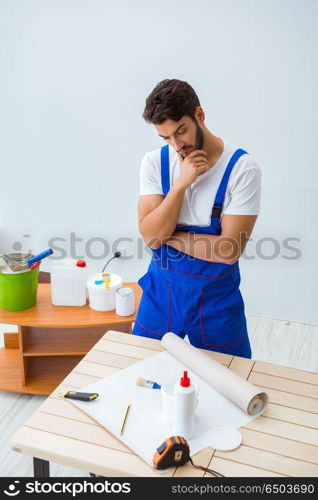 Worker working on wallpaper during refurbishment