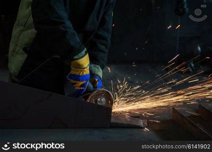 worker works with metal, sparks at factory