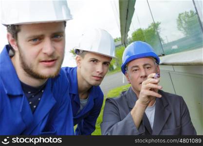 workers and architect watching some details on a construction