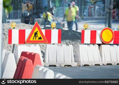 "Workers are Repairing the Road on the City Street. The Road is Fenced with the Signs of "Danger" and "Road Repair""