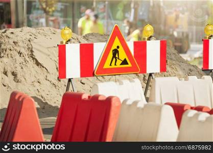 "Workers are Repairing the Road on the City Street. The Road is Fenced with the Signs of "Danger" and "Road Repair""