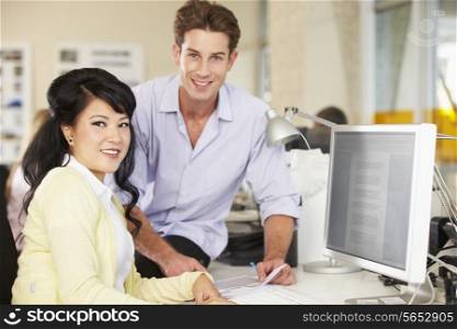 Workers At Desk In Busy Creative Office