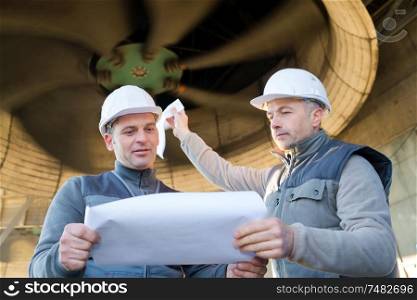 workers checking plans in a factory