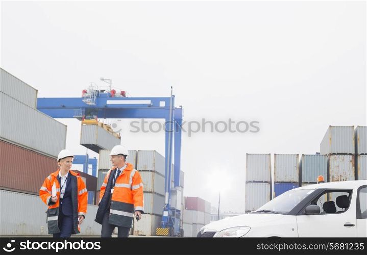 Workers conversing while walking in shipping yard