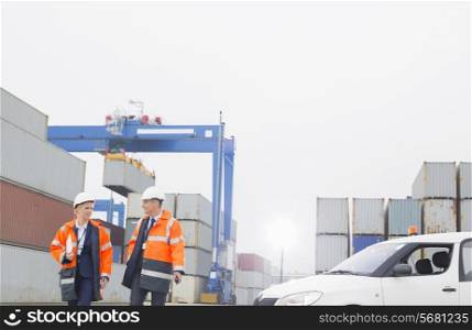 Workers conversing while walking in shipping yard