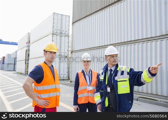 Workers discussing in shipping yard
