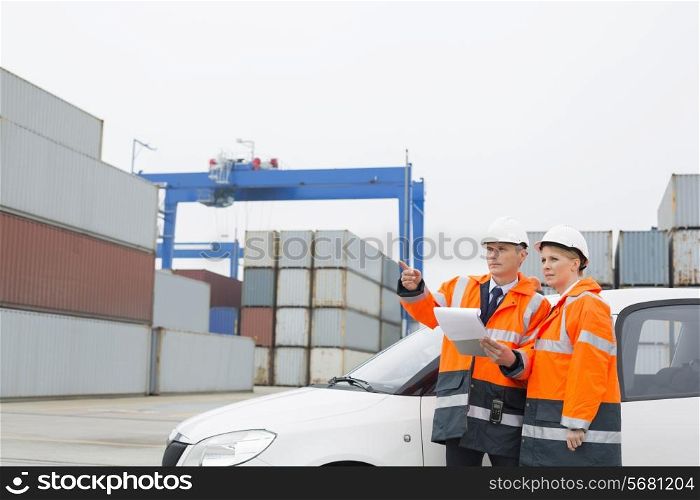 Workers examining cargo in shipping yard