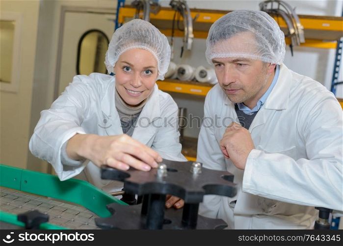 workers holding an equipment in bottling plant