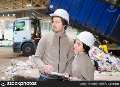 workers in a recycle center lorry tipping in background