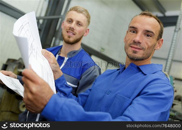 workers in overalls studying the blueprint