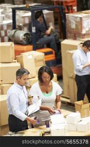 Workers In Warehouse Preparing Goods For Dispatch