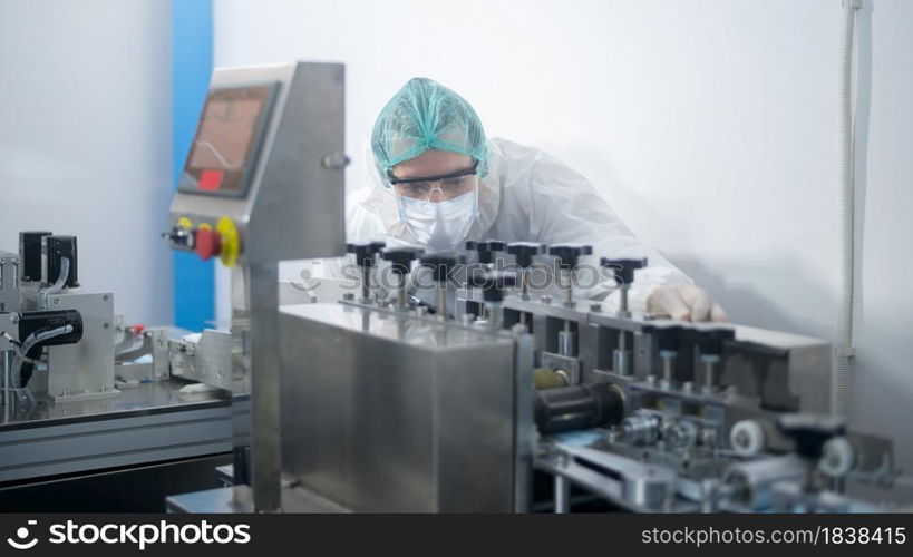 Workers producing surgical mask in modern factory, Covid-19 protection and medical concept.