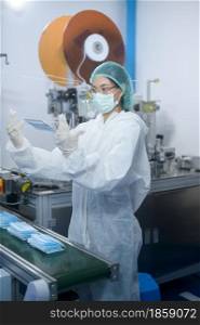 Workers producing surgical mask in modern factory, Covid-19 protection and medical concept.
